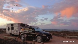 Mercedes van with caravan and antenna mast at sunset